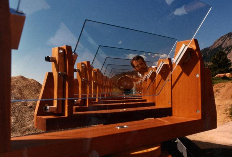 1980s: Tim Brown is shown with what was called the Redwood Telescope. Its aim was to measure atmospheric scintillation noise in stellar photometry, using the multiple panes of glass as mirrors to feed light from a star to a single 8-inch telescope. Since each pane sees the star through a different volume of atmosphere, the scintillation noise for the sum should be smaller than for the same-size telescope looking directly at the star. The redwood part was designed and built by Lee Lacey.